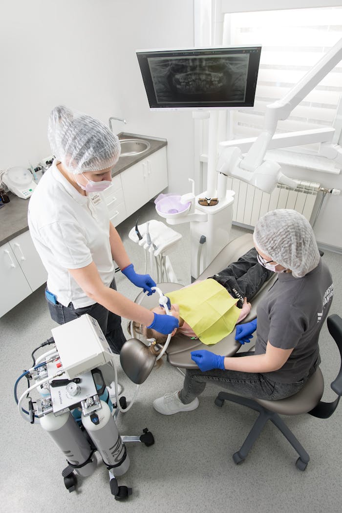 services-01 Overhead view of a dental procedure with a dentist and patient, showcasing modern dental equipment and care.